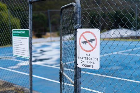 Foto de Pista de tenis gobierna en un cartel que dice que no hay patinetas y no hay perros - Imagen libre de derechos