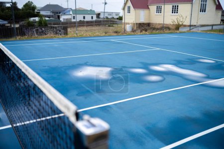 Photo for Wet tennis court with puddles on a public sport court i - Royalty Free Image