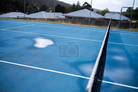 Photo for Wet tennis court with puddles on a public sport court i - Royalty Free Image