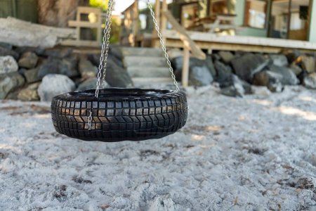 Plüschtiere schaukeln im Sommer auf einer Reifenschaukel am Strand