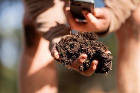 agriculteur tenir le sol dans les mains de surveillance de la santé du sol sur une ferme en Amérique
