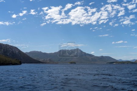 Yacht sailing on the horizon near the beach on the ocean ina  remote beautiful landscape, Tasmania, Australia 