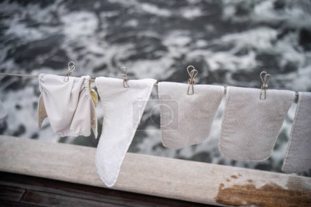 clothes drying on a washing line on a yacht boat traveling over the ocean on holiday. nappies drying on a clothesline 