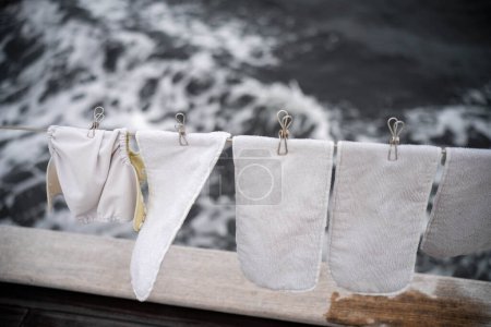 clothes drying on a washing line on a yacht boat traveling over the ocean on holiday. nappies drying on a clothesline 