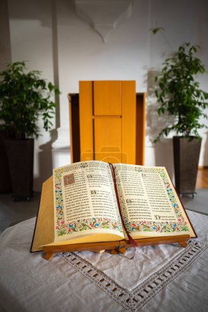 Téléchargez les photos : Embrach, Suisse - 23 octobre 2022 : Un livre biblique ouvert sur une table dans l'église évangélique réformée d'Embrach. - en image libre de droit