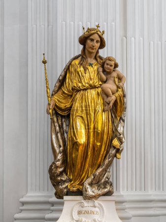 Foto de Solothurn, Switzerland - July12, 2022: Gilded statue of Mary, Queen of peace, with child Jesus in the cathedral of Solothurn, Switzerland. - Imagen libre de derechos