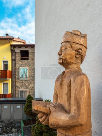 Téléchargez les photos : Sutrio, Italy - December 29, 2022: a Wooden sculpture of a village pastor with an open book - en image libre de droit