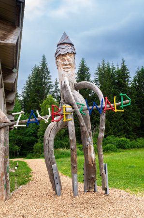 Téléchargez les photos : Bernau, Allemagne - 1er juillet 2023 : La figure naine en bois au début du sentier forestier magique à travers le paysage de haute lande des Taubenmoos à Bernau, région de la Forêt-Noire en Allemagne. - en image libre de droit