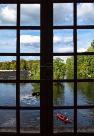 Foto de Chenonceau, Francia - 8 de agosto de 2023: La vista desde la ventana del castillo de agua de Chenonceau en el río Loira. Un kayak remando. - Imagen libre de derechos