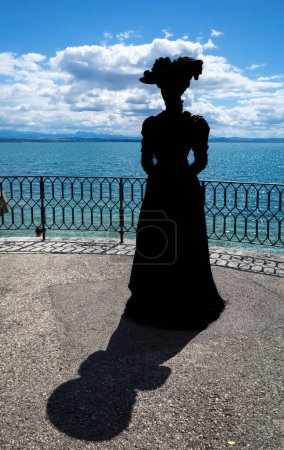 Photo for Neuchatel, Switzerland - August 7, 2023: Silhouette of a bourgeois lady from the past on the shore of Lake Neuchatel - Royalty Free Image