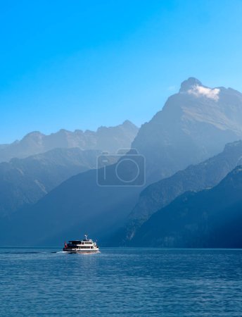 Umrisse der Berge am Schweizer Urnersee - dem Vierwaldstättersee - im Tagesnebellicht. Touristenschiff auf dem See.
