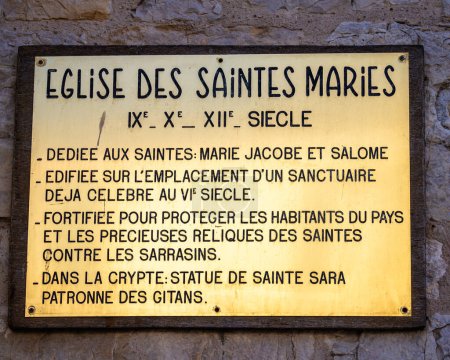 Photo for Saintes Maries de la Mer, France - October 3, 2023: Information signboard in Saintes Maries de la Mer explaining in french the history and the meaning of the church - Royalty Free Image