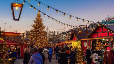 Foto de Zurich, Suiza - 23 de noviembre de 2023: Mercado de Navidad frente a la ópera en la plaza Sechselautenplatz-Bellevue de Zurich al atardecer - Imagen libre de derechos