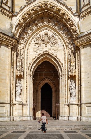 Téléchargez les photos : Orléans, France - 10 août 2023 : Un homme marchant en fron de l'entrée principale de la Sainte-Croix - Sainte-Croix - cathédrale d'Orléans. - en image libre de droit