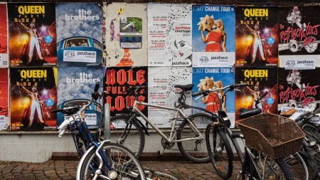 Photo for Freiburg im Breisgau, Germany - December 28, 2023: A wall plastered with advertising posters and concert announcements. Bicycles are parked in front - Royalty Free Image