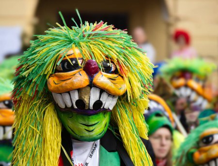 Téléchargez les photos : Fribourg-en-Brisgau, Allemagne - 12 février 2024 : Mascarade. Beau masque dans un défilé de carnaval avec des gens flous en arrière-plan. - en image libre de droit
