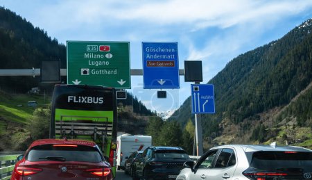 Téléchargez les photos : Goschenen, Suisse - 6 avril 2024 : Véhicules en file d'attente devant le tunnel autoroutier du Gothard. Compagnie de transport par autobus Flixbus. - en image libre de droit