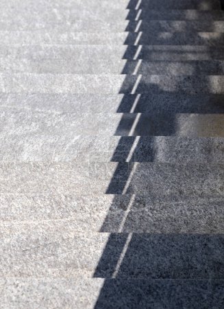 Captura el juego de la luz y la sombra en escaleras de piedra al aire libre, creando un patrón geométrico llamativo bajo la luz solar brillante.