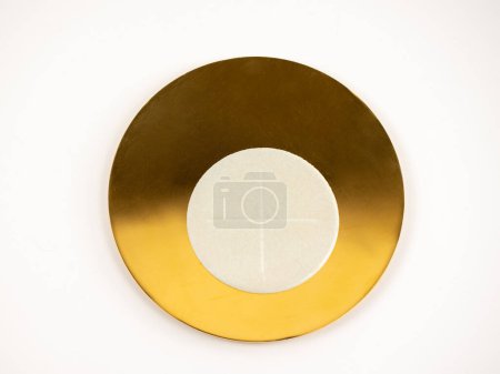 Gilded paten with white altar bread - holy bread, white background