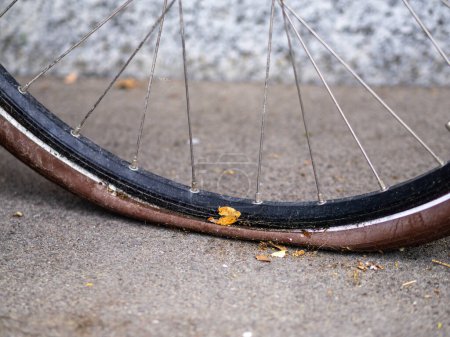Close-up of a deflated bicycle tire on a concrete surface outdoors.