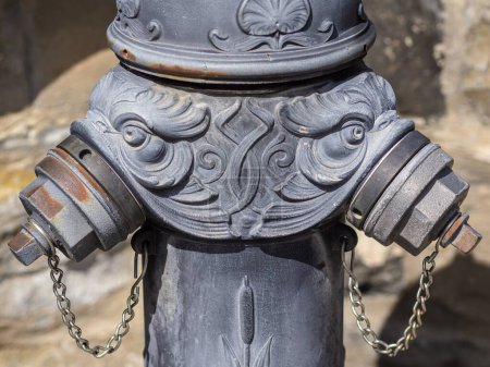 A vintage cast iron fire hydrant adorned with ornate floral designs