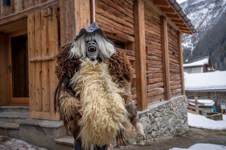 Photo for Reveller wearing wooden mask and carnival costume. Evolene, Valais Canton, Switzerland. - Royalty Free Image