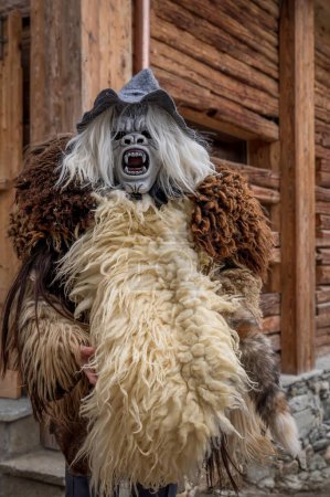 Photo for Reveller wearing wooden mask and carnival costume. Evolene, Valais Canton, Switzerland. - Royalty Free Image