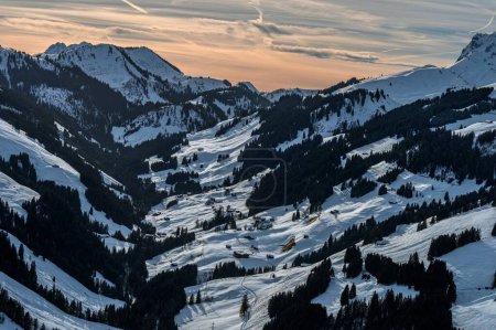 Winter landscape of Swiss village in Switzerland. Mountain, sky and Swiss chalet. Jaunpass, Fribourg Canton, Switzerland.