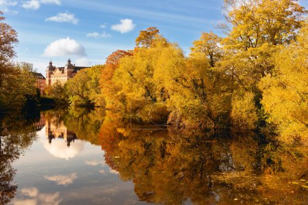 Téléchargez les photos : Arbres en automne reflétés dans la rivière. Dans des couleurs chaudes jaune et orange - en image libre de droit