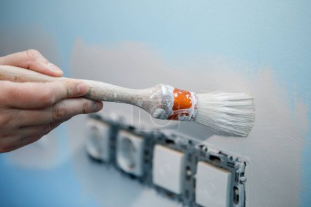 Travaux de préparation pour peindre le mur de la maison, bordure des douilles avant de rouler le rouleau