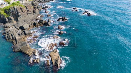 Foto de Las olas ceruleas chocan contra el promontorio rocoso - Imagen libre de derechos