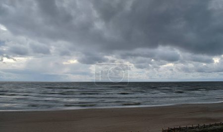 Photo for Seascape. Rough Baltic Sea and sandy shore under thunderclouds. - Royalty Free Image