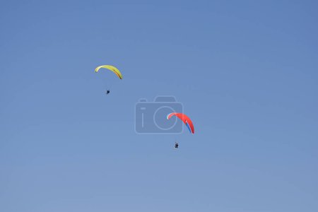 Foto de Dos parapentes voladores en un cielo azul sin nubes. - Imagen libre de derechos