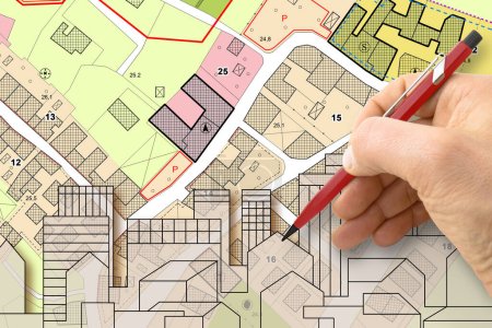 Architect drawing buildings over an imaginary cadastral map of territory and General Urban Plan with indications of urban destinations with buildings, roads, buildable areas and land plot 