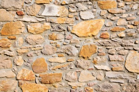Téléchargez les photos : Ancien mur construit avec des blocs de pierre de forme irrégulière récemment restauré - en image libre de droit