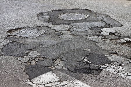 Téléchargez les photos : Vieux fond de route asphaltée endommagé, dangereux et cassé - en image libre de droit