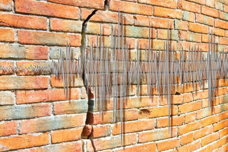 Téléchargez les photos : Earthquake wave graph concept against a cracked and damaged brick wall - en image libre de droit