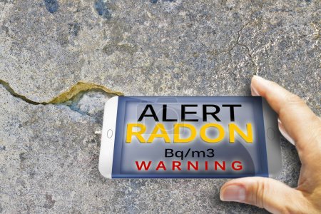 Foto de Portable information device for monitoring radioactive gas radon - radon testing concept image against a cracked wall. - Imagen libre de derechos