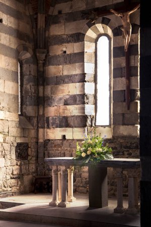 Photo for Stone altar with flowers in an ancient italian Romanesque church - Royalty Free Image