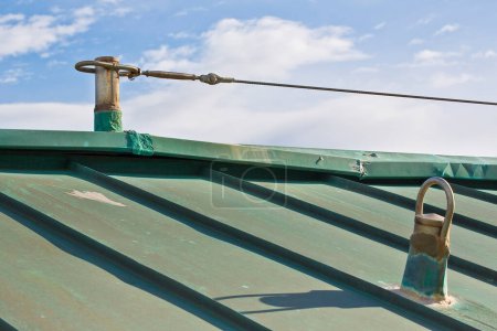 Téléchargez les photos : Système horizontal de protection contre les chutes avec câble inox en acier inoxydable sur le toit en cuivre utilisé pour prévenir le risque de chute - en image libre de droit
