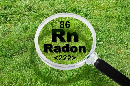 El peligroso gas radón natural radiactivo bajo el suelo - concepto con tabla periódica de los elementos, lente de aumento y área de hierba verde