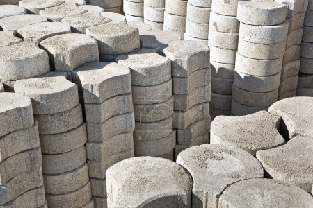 Photo for Stack of concrete self locking flooring blocks in curved shape on wooden pallet in a construction site - used in construction industry to create permeable floors to rain water on a layer of sand - Royalty Free Image