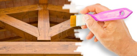 Photo for Care, maintenance and renovation of wooden structures with beams and wooden roof - concept with hand and brush - Royalty Free Image