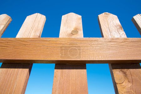Detail of a wooden fence against a blue sk