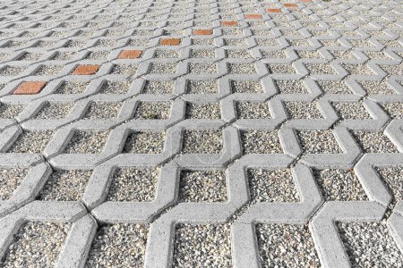 Photo for Concrete self locking tiled and draining flooring blocks assembled on a substrate of sand with gravel - type of flooring permeable to rain water as required by laws used in car parking areas - Royalty Free Image