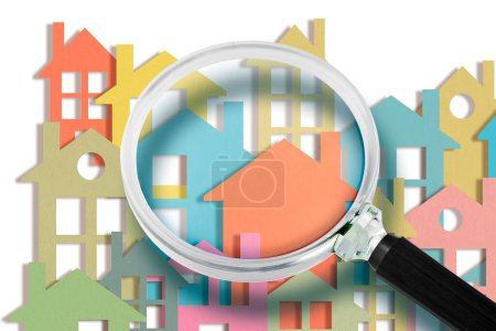 Real estate agent looks at the houses through a magnifying glass - Searching new home concept with colorful houses 