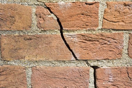 Photo for Dangerous old exposed brick wall with deep crack due to structural foundation failure, soil subsidence, corrosion and deterioration of building materials, Climate and seasonal changes, earthquake - Royalty Free Image
