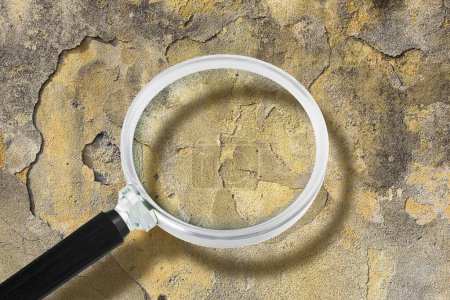 Photo for Old unhealthy plaster wall damaged by rising damp or from water leaks with salt minerals on surface level - concept with magnifying glass - Royalty Free Image