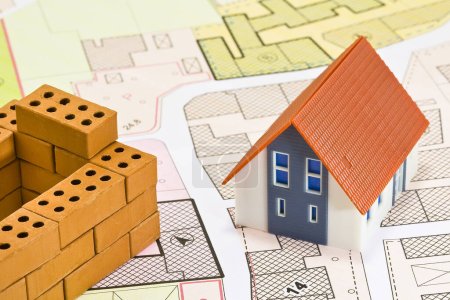 Allgemeiner Stadtplan und Flächennutzungsplan Karte mit Gebäuden und Wohnmodell mit kleinen Terrakottasteinen - Hausbau und Bauaktivitätskonzept