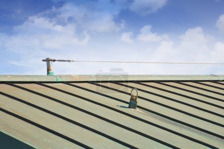Téléchargez les photos : Système horizontal de protection contre les chutes avec câble inox en acier inoxydable sur le toit en cuivre utilisé pour prévenir les risques de chute - bâtiments et accéder en toute sécurité à toutes les zones d'un toit - en image libre de droit